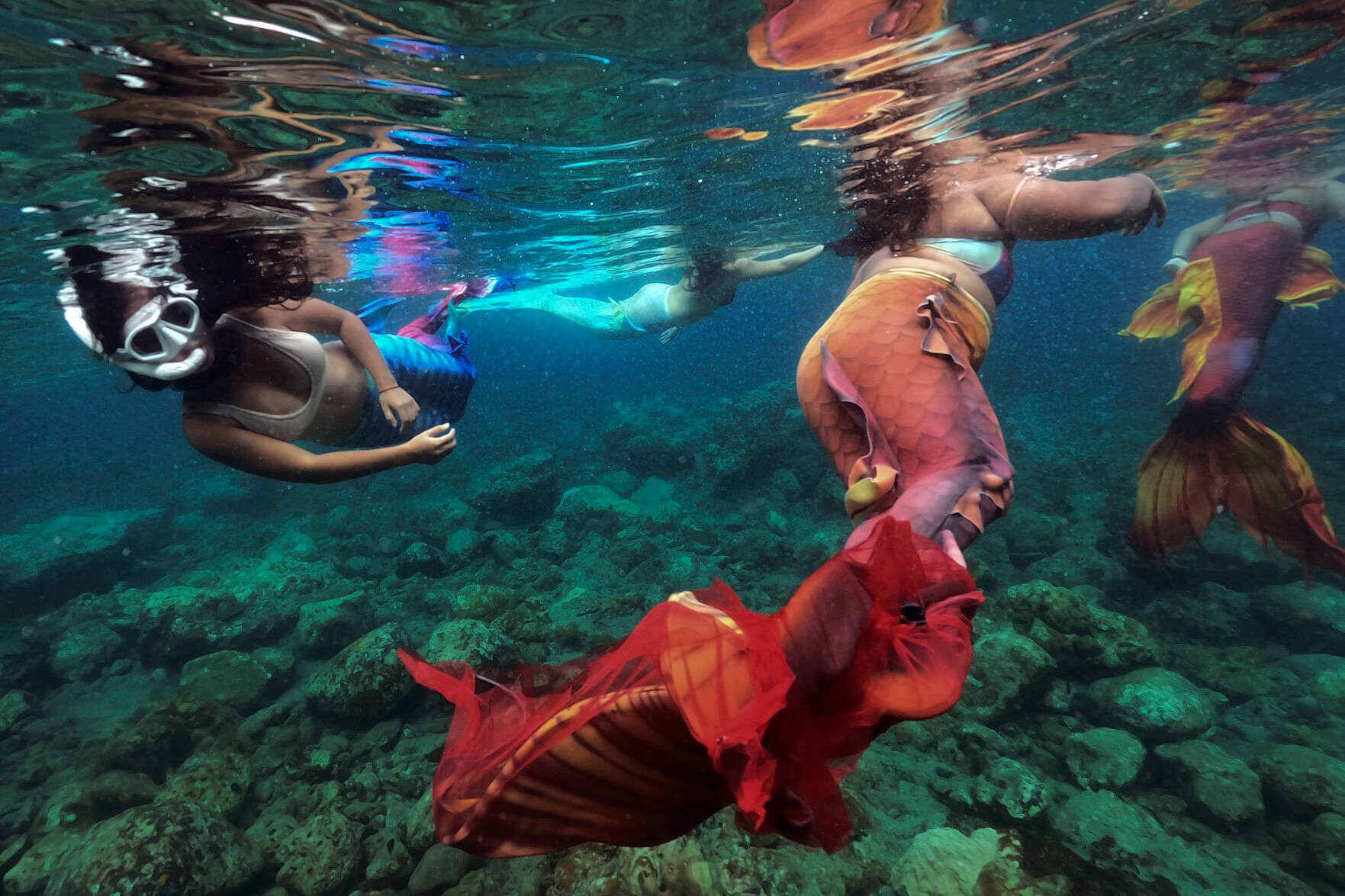 <p>Filipina Jennica Secuya, left, swims with other students during a mermaiding class in Mabini, Batangas province, Philippines on Sunday, May 22, 2022. </p>