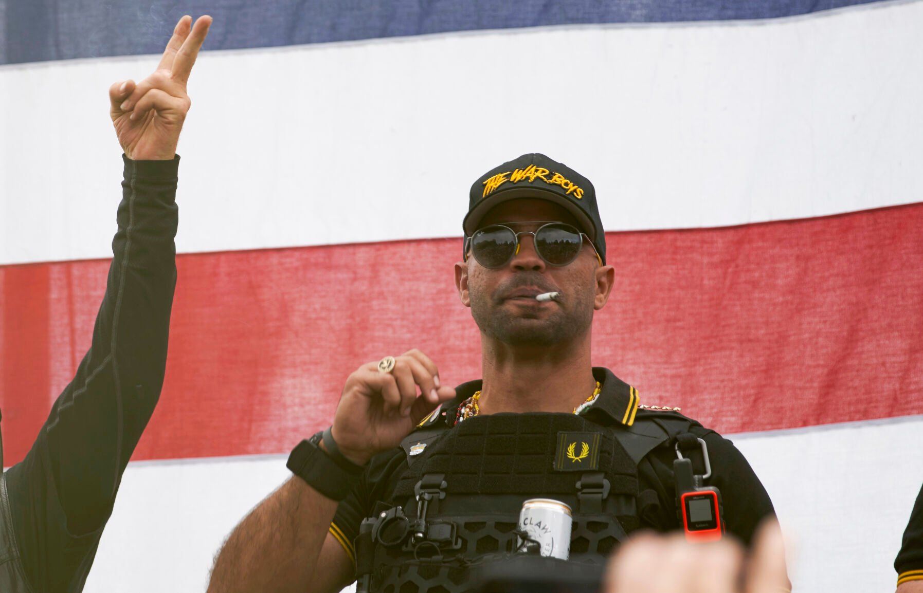 <p>FILE - Proud Boys leader Enrique Tarrio wears a hat that says The War Boys and smokes a cigarette at a rally in Delta Park on Sept. 26, 2020, in Portland, Ore. </p>
