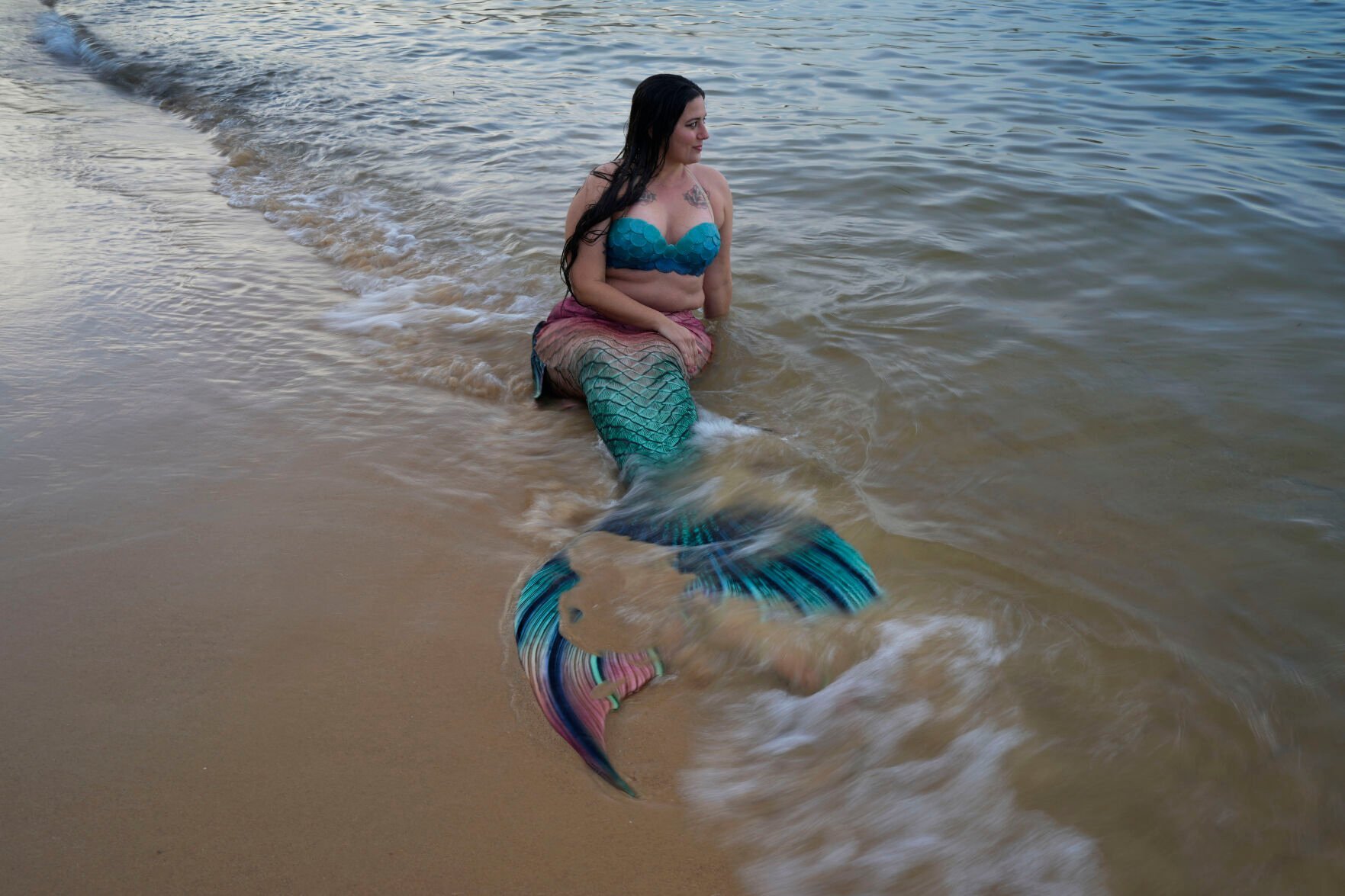 <p>Lauren Metzler, founder of Sydney Mermaids, prepares for a swim at Manly Cove Beach in Sydney, Australia, Thursday, May 26, 2022. “The more we open up our imagination and accept everyone for how they are, it makes it more of a beautiful experience,” she says. “The sky _ or ocean floor _ is the limit of what you can do with mermaiding.” </p>