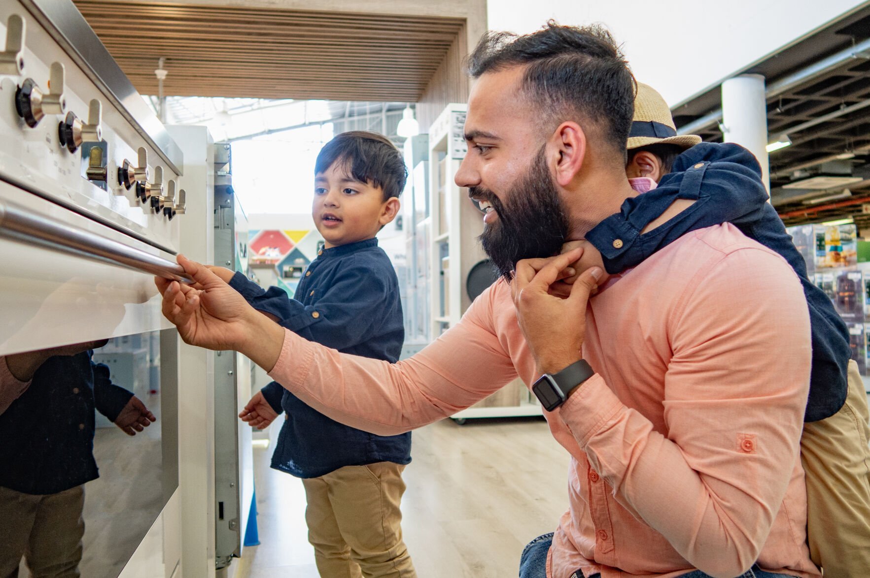 <p>A father and two sons go shopping for household appliances in a large warehouse store</p>