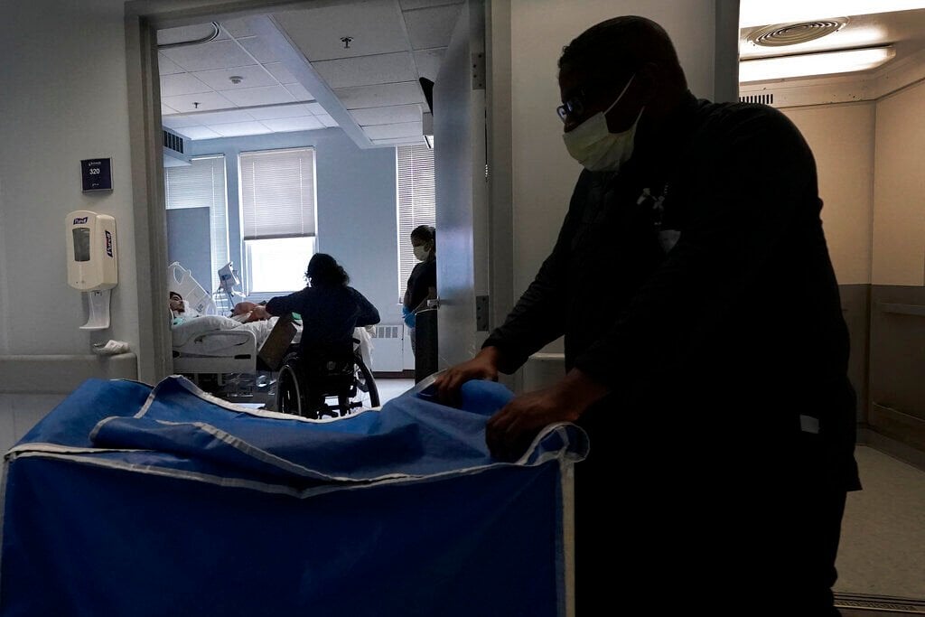 <p>Jonathan Annicks, who is a part-time peer mentor for patients with spinal cord injuries at Schwab Rehabilitation Hospital, visits patient Misael Suarez and his mother Minerva as an orderly passes by Tuesday, March 29, 2022, in Chicago. </p>