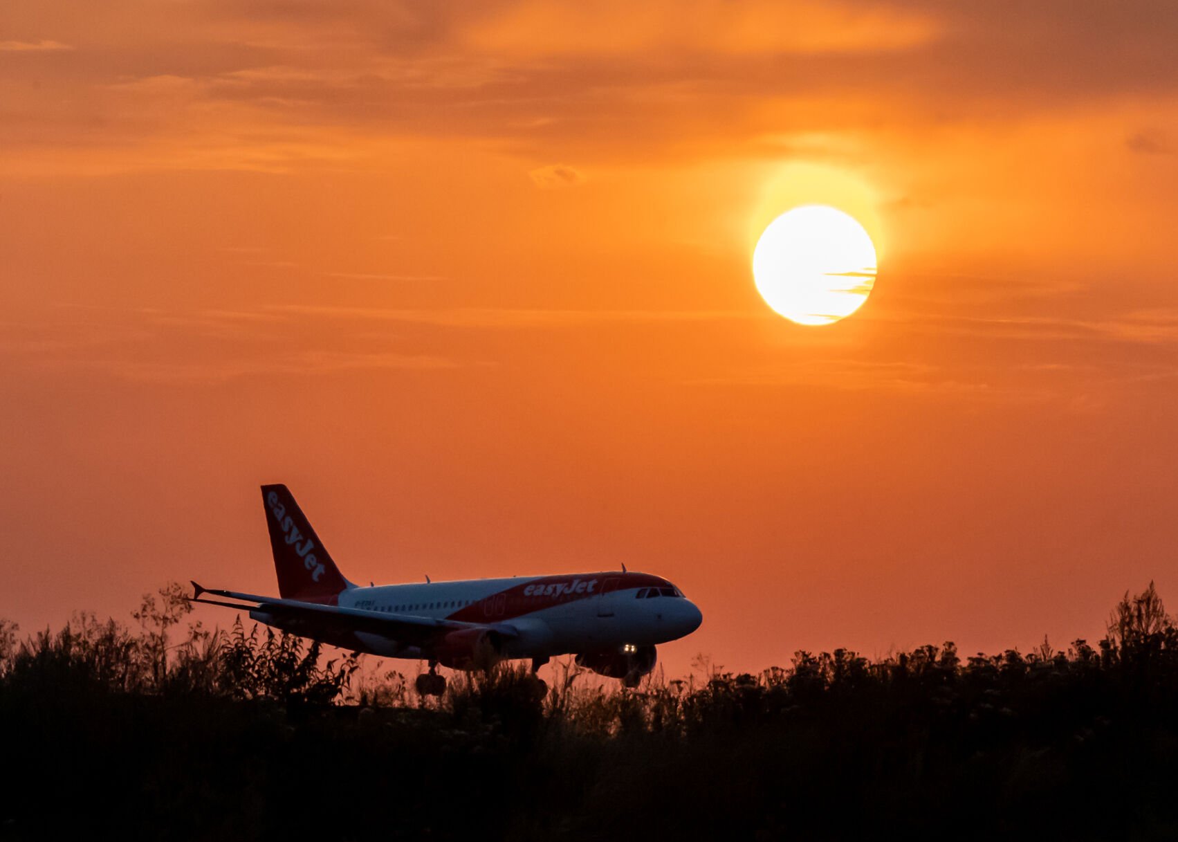 <p><span>An Easy Jet plane lands during sunset at Luton Airport after a small section of the runway had lifted due to high temperatures on July 18, 2022.</span></p>