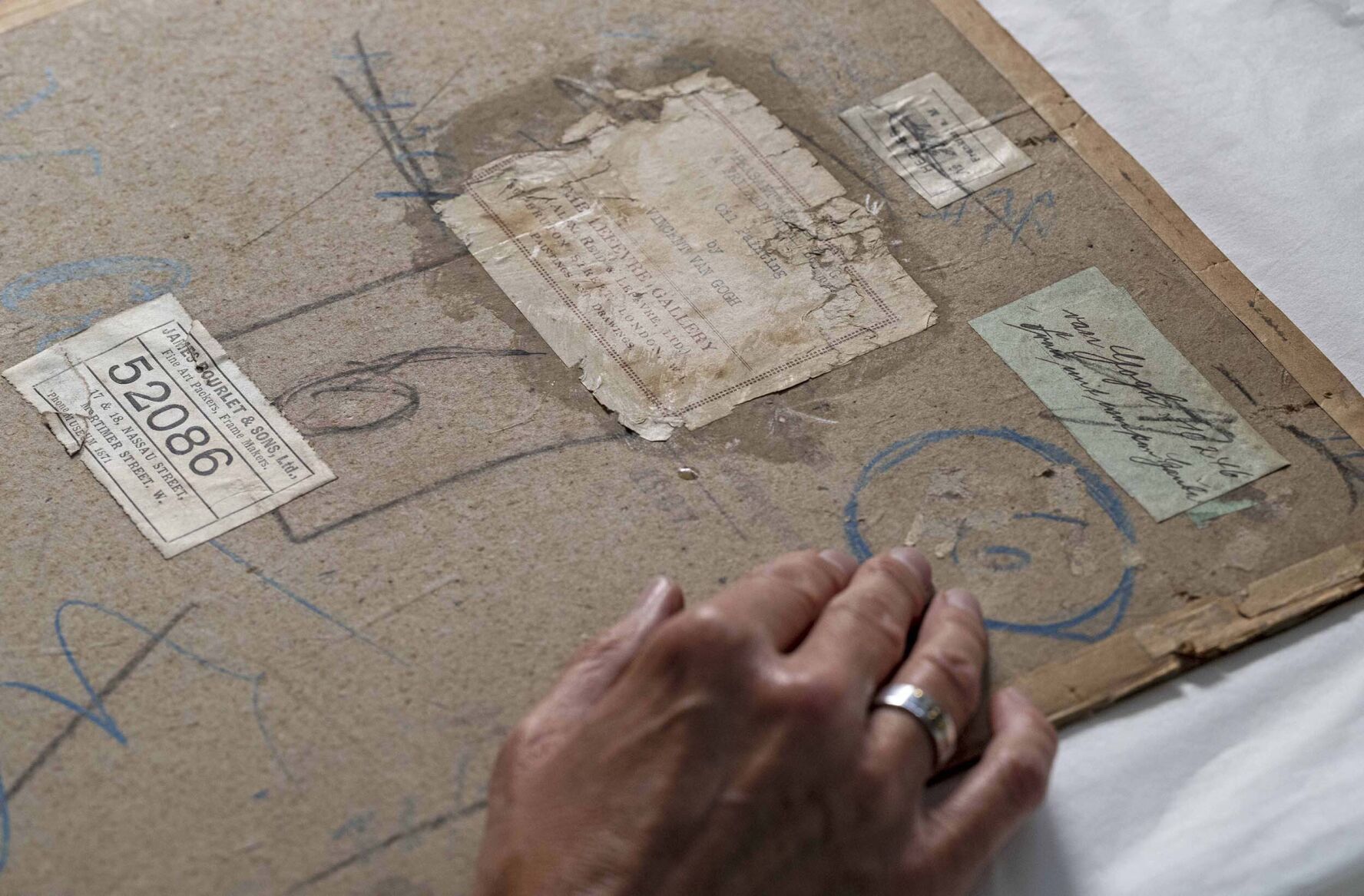 <p>Research is ongoing as to how the glue and cardboard can be delicately removed without harming "Head of a Peasant Woman."</p>