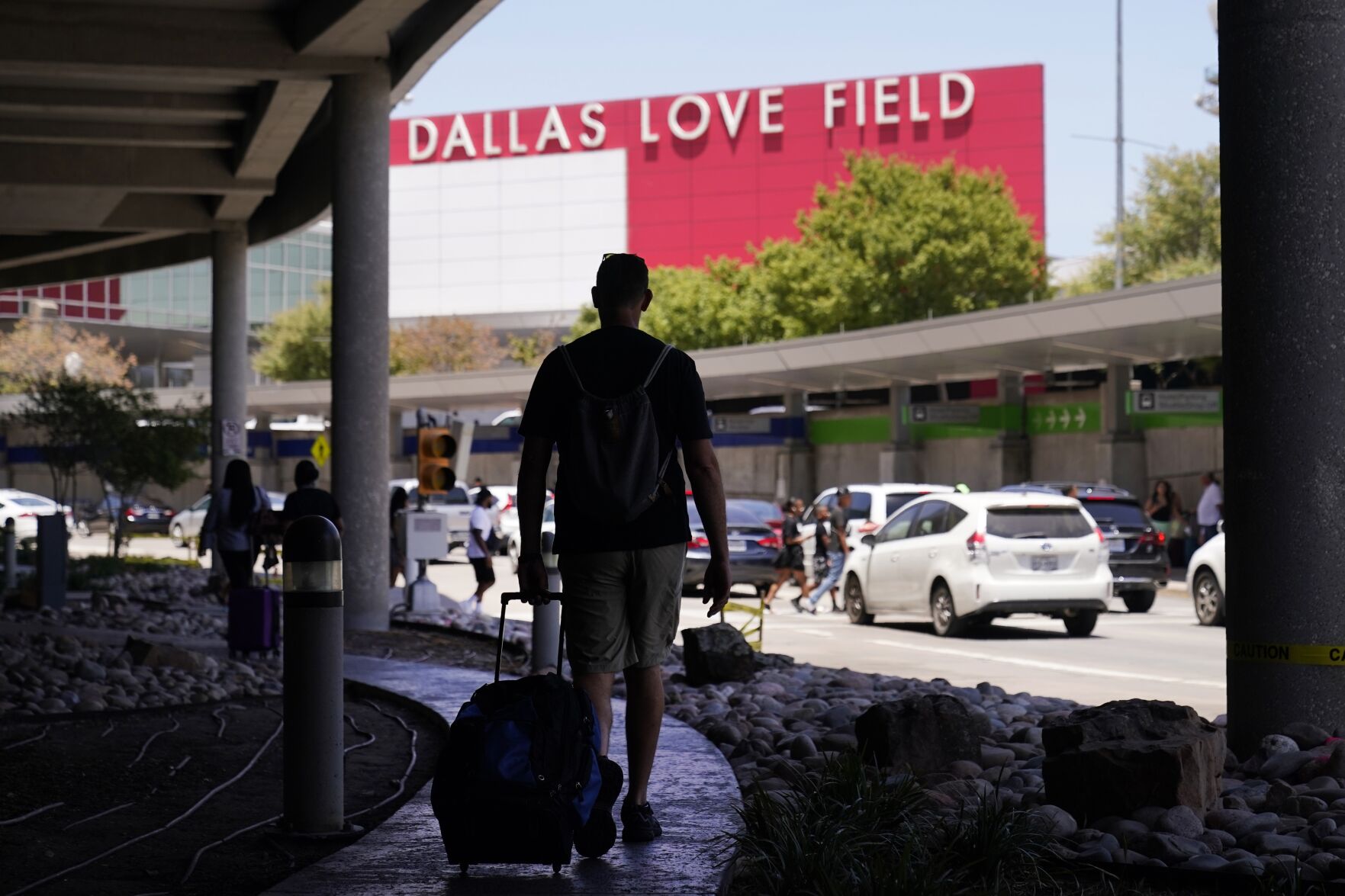 <p>Travelers approach the main entrance at Dallas Love Field in Dallas, Monday, July 25, 2022. A 37-year-old woman fired several gunshots, apparently at the ceiling, inside of Dallas' Love Field Airport on Monday before an officer shot and wounded her, authorities said.</p>