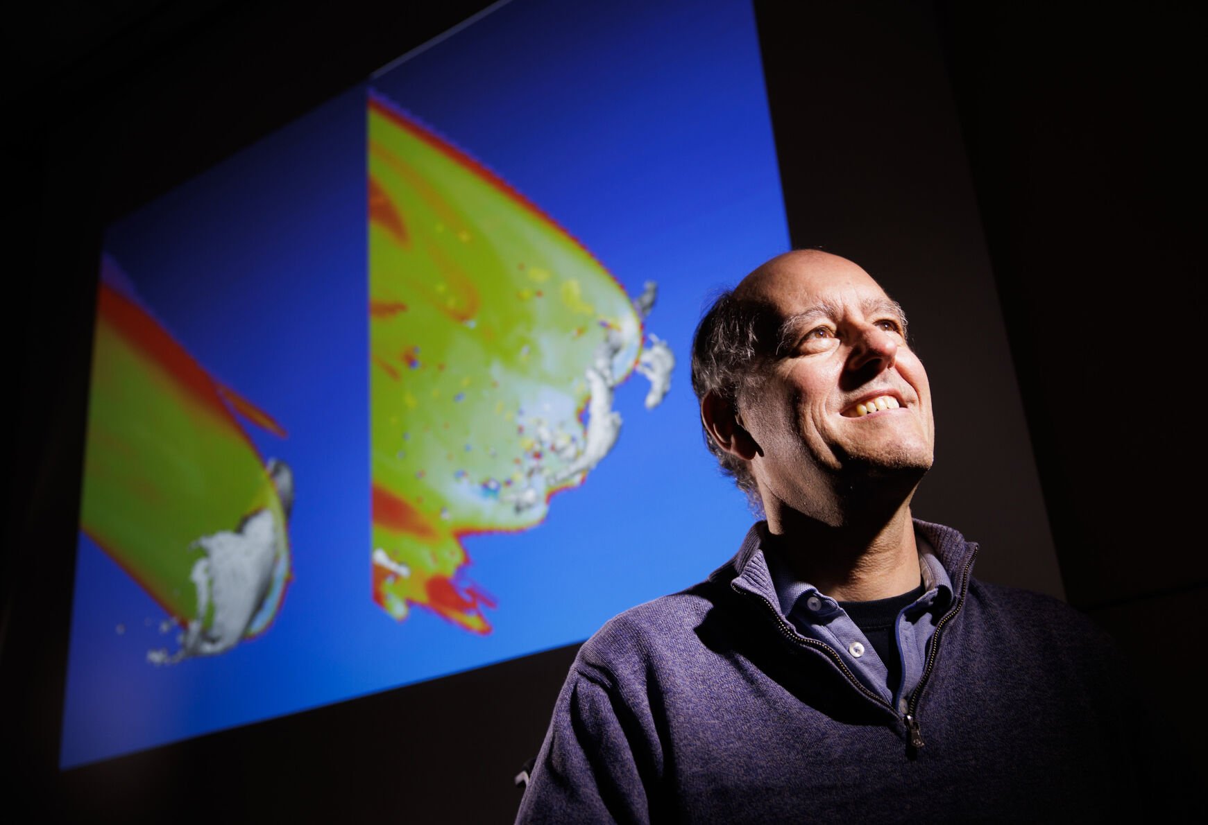 <p>Meteor astronomer Peter Jenniskens poses for a portrait with a computer simulation of asteroid 2008 TC3 as it entered the Earth's atmosphere.</p>