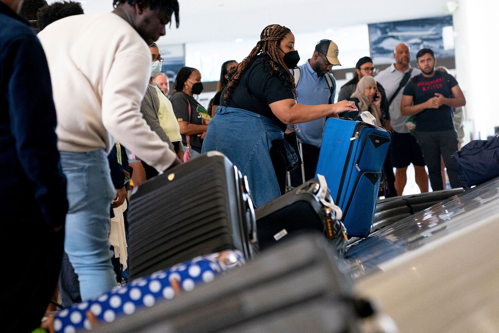 <p>Travelers pick up their baggage while arriving at Ronald Reagan Washington National Airport in Arlington, Virginia, on July 2.</p>