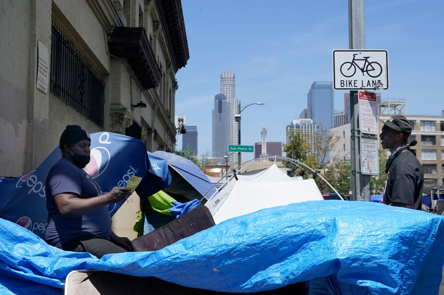 <p>LA CAN outreach worker and human rights organizer, Steve Richardson, who goes by General Dogon, reaches out to homeless people in the Skid Row area of Los Angeles Friday, July 22, 2022. “Police should be nowhere around outreach. You can’t be the provider of services as well as the jailer,” said Pete White, the founder and executive director of the Los Angeles Community Action Network. “My hope ... is that those resources that go to the police department are actually pointed towards real solutions.” </p>