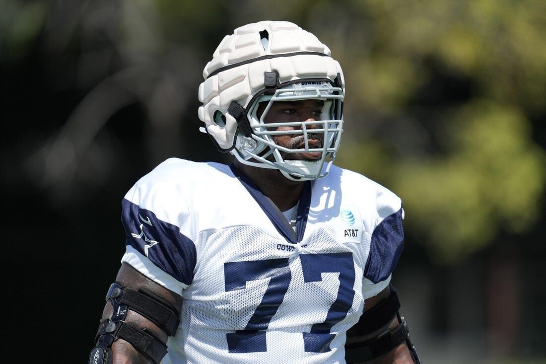 <p>Aug 18, 2022; Costa Mesa, CA, USA; Dallas Cowboys offensive tackle Tyron Smith (77) wears a Guardian helmet cap during joint practice against the Los Angeles Chargers at Jack Hammett Sports Complex. Mandatory Credit: Kirby Lee-USA TODAY Sports</p>