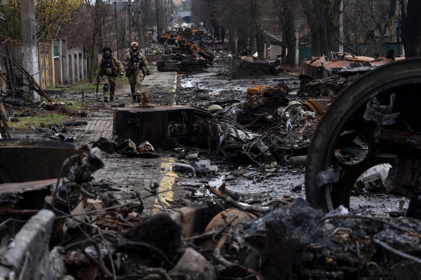 <p>Soldiers walk amid destroyed Russian tanks in Bucha, in the outskirts of Kyiv, Ukraine, April 3, 2022. </p>