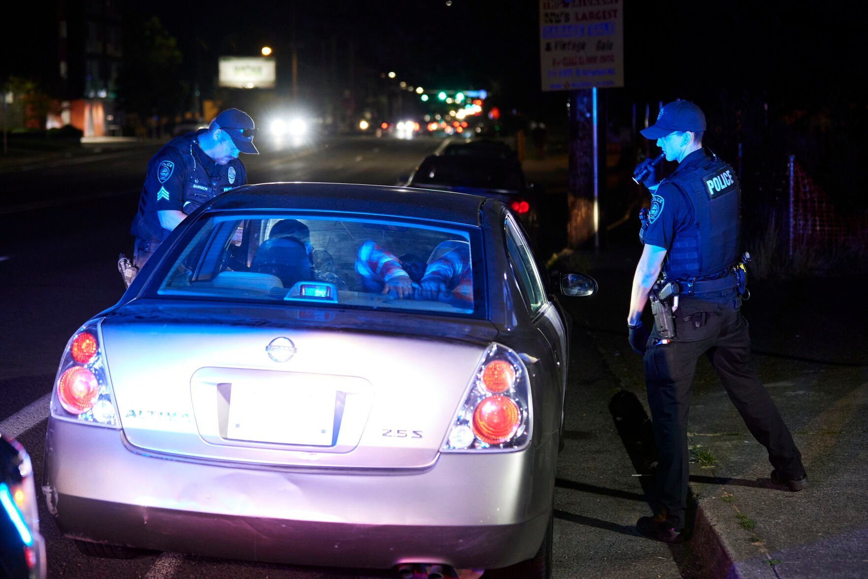 <p>Gresham Police Sgt. Travis Garrison, left, and Officer Ryan Gomez look inside a vehicle during a traffic stop in Gresham, Ore., Thursday, July 21, 2022. </p>
