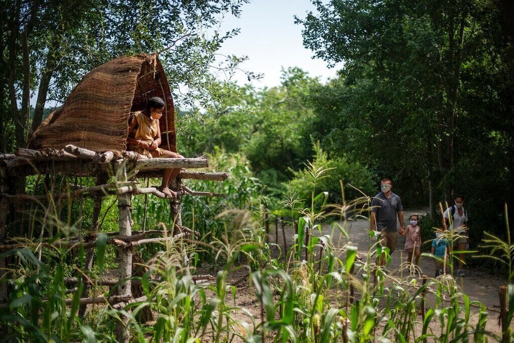 <p>Alyssa Harris, a member of the Mashpee Wampanoags and a museum educator at Plimoth Patuxet Museums sits in a corn watch tower as visitors walk through the Wampanoag Homesite living history exhibit, Wednesday, Aug. 12, 2020, in Plymouth, Mass. Native Americans in Massachusetts are calling for a boycott of a popular living history museum featuring colonial reenactors portraying life in Plymouth, the famous English settlement founded by Pilgrims arriving on the Mayflower. They say the Plimoth Patuxet museum hasn't lived up to its mandate to create a "bi-cultural museum" telling equally the stories of the European and indigenous communities. (AP Photo/David Goldman, File)</p>