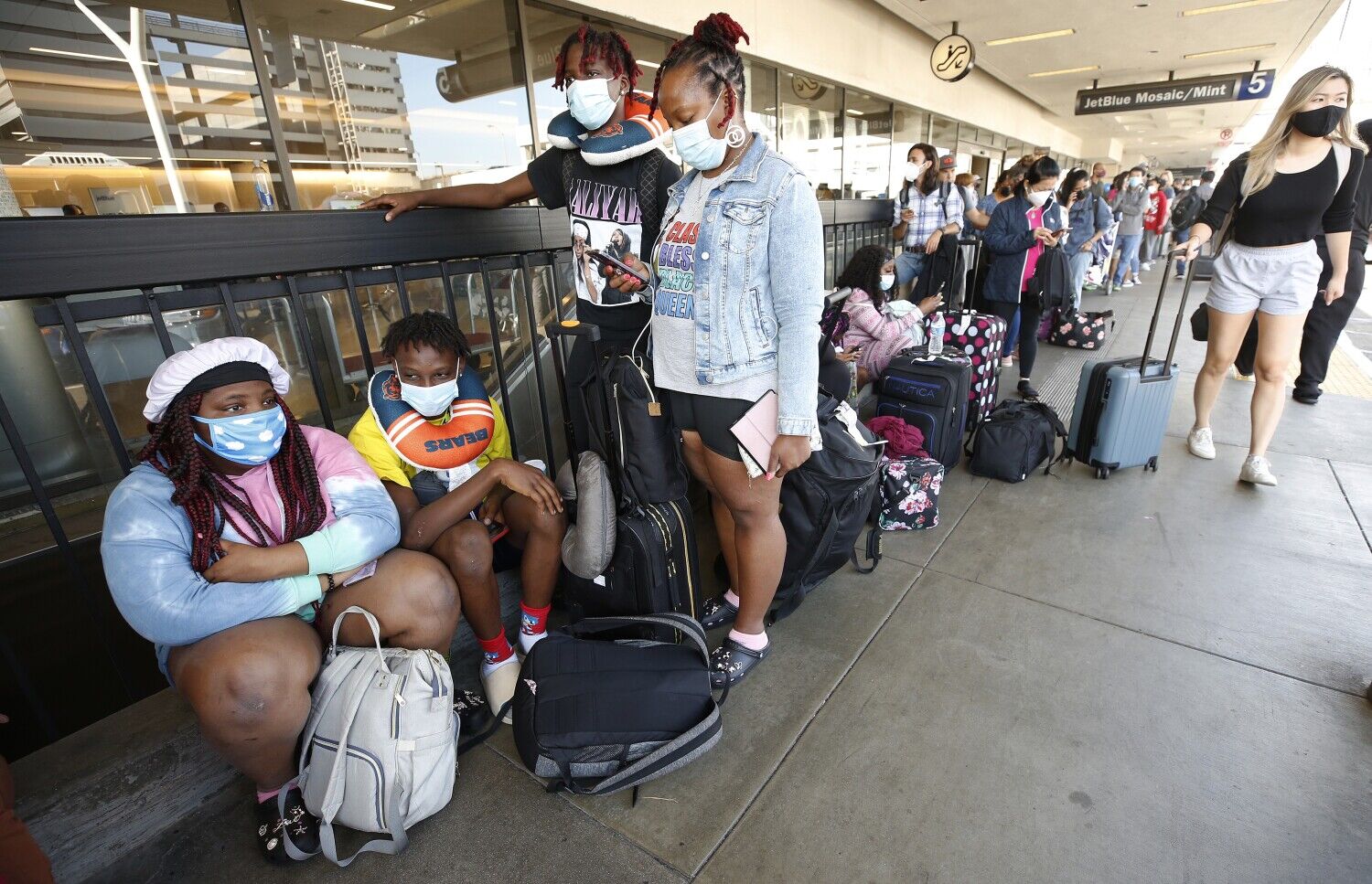 <p>From left, Kyrianna, Te'Shawn and Brandon Hill, with their mother Katyra Henderson-Hill, wait for a flight home to Chicago from Los Angeles International Airport on Aug. 3, 2021 in Los Angeles. (Al Seib/Los Angeles Times/TNS).</p>