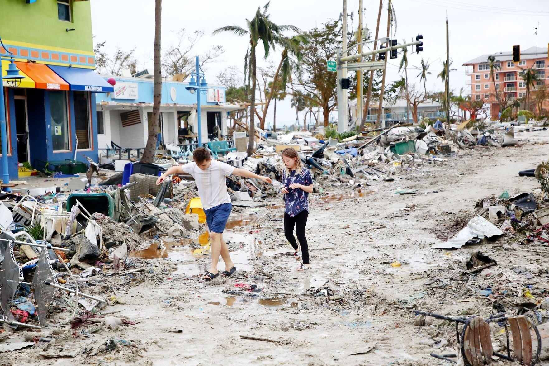 <p>Jake Moses, 19, left, and Heather Jones, 18, of Fort Myers, Florida, explore a section of destroyed businesses at Fort Myers Beach on Thursday.</p>