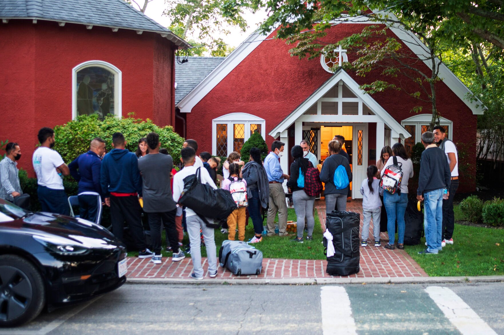 <p>Immigrants gather with their belongings outside St. Andrews Episcopal Church on Sept. 14, 2022, in Edgartown, Mass., on Martha's Vineyard.</p>