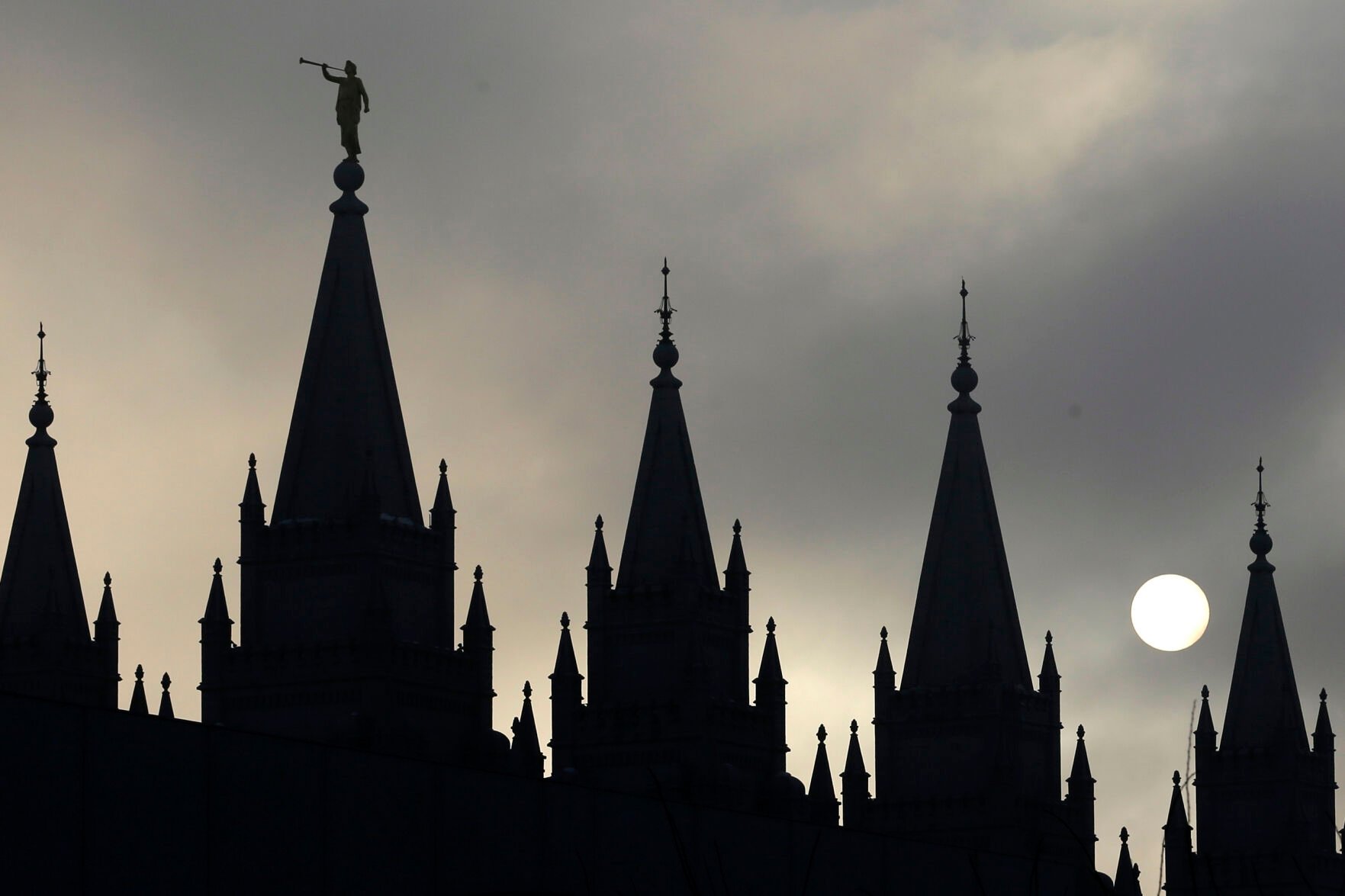 <p>FILE - The angel Moroni statue atop the Salt Lake Temple is silhouetted against a cloud-covered sky, at Temple Square in Salt Lake City on Feb. 6, 2013. (AP Photo/Rick Bowmer, File)</p>