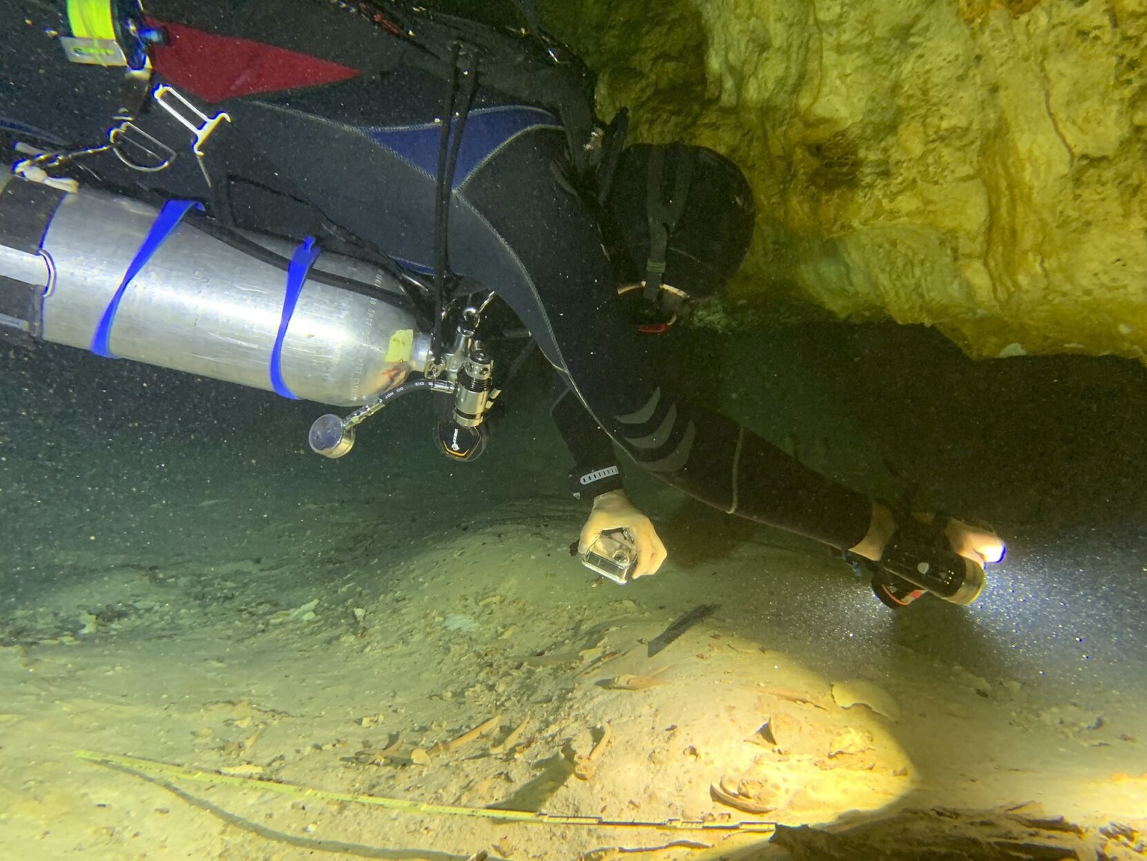 <p>In this photo courtesy of Peter Broger, aquatic archaeologist Octavio del Rio films a prehistoric human skeleton partly covered by sediment in an underwater cave in Tulum, Mexico.</p>