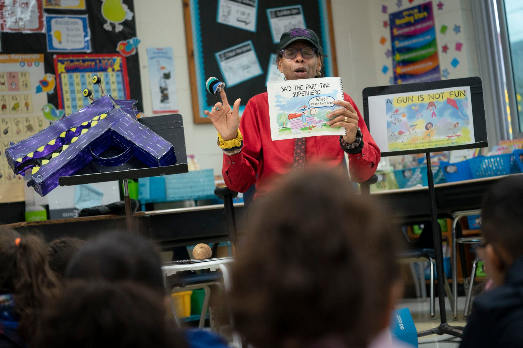 <p>Ian Ellis James, an Emmy award-winning Sesame Street writer known by his stage name William Electric Black, leads a first grade class in a book reading on urban gun violence prevention at the Drexel Avenue School, Monday, Oct. 3, 2022, in Westbury, New York. Black is the author of the illustrated children’s book “A Gun Is Not Fun.” He said young children in areas afflicted by gun violence are more aware of it than parents may think. </p>