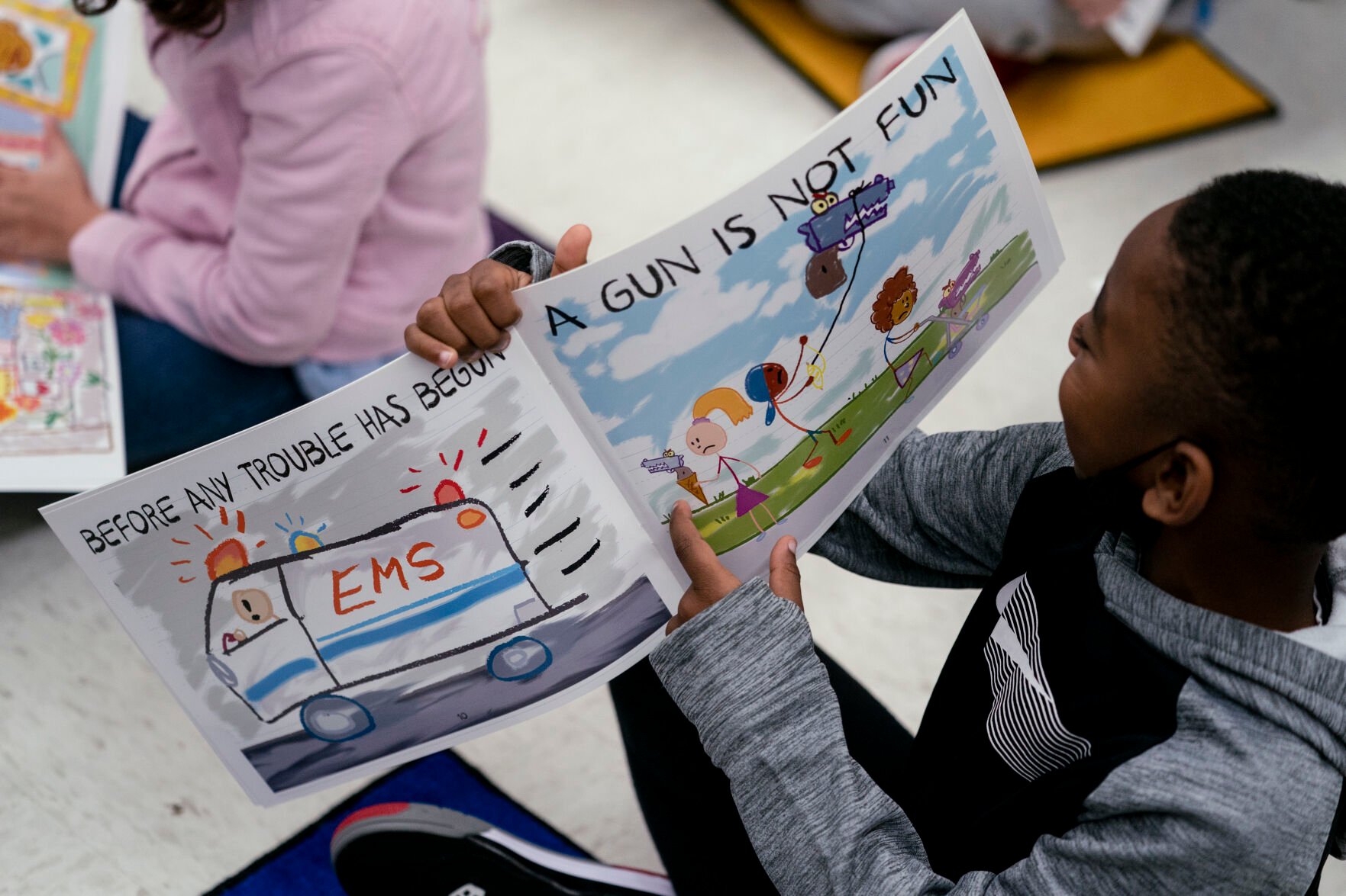 <p>Children read as Ian Ellis James, an Emmy award-winning Sesame Street writer known by his stage name William Electric Black, leads a first grade class in a book reading on urban gun violence prevention at the Drexel Avenue School, Monday, Oct. 3, 2022, in Westbury, N.Y. </p>