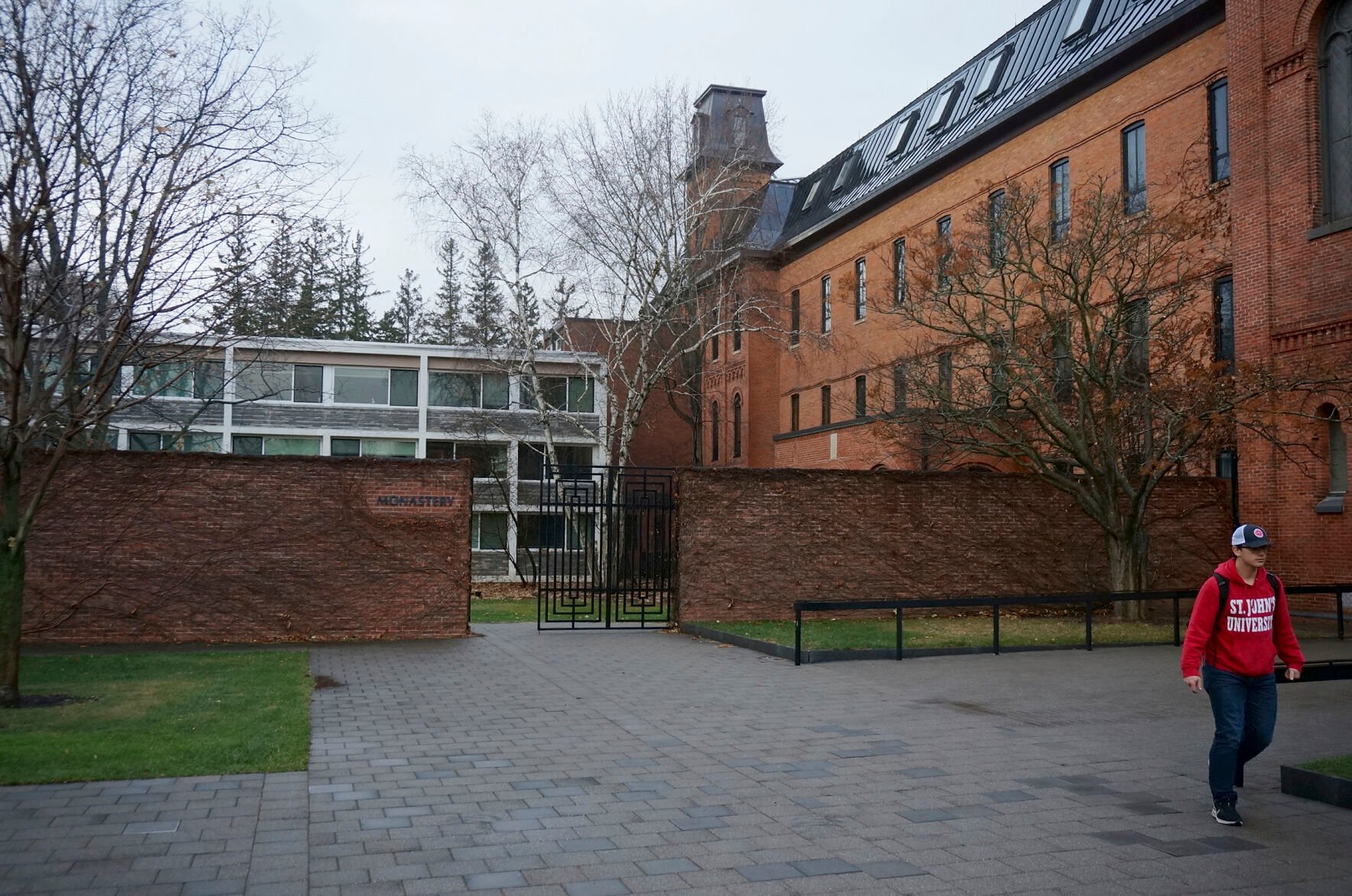 <p>A person walks in front of the Benedictine abbey on the campus of Saint John's University in Collegeville, Minn., on Tuesday, Nov. 8, 2022.</p>