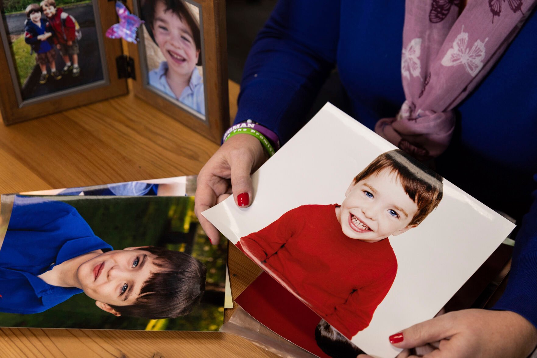 <p>Co-founder and CEO of Sandy Hook Promise Foundation Nicole Hockley shows photos of her son, Dylan, in her office Dec. 5 in Newtown, Conn. Dylan was among the 20 children killed at Sandy Hook Elementary School a decade ago.</p>