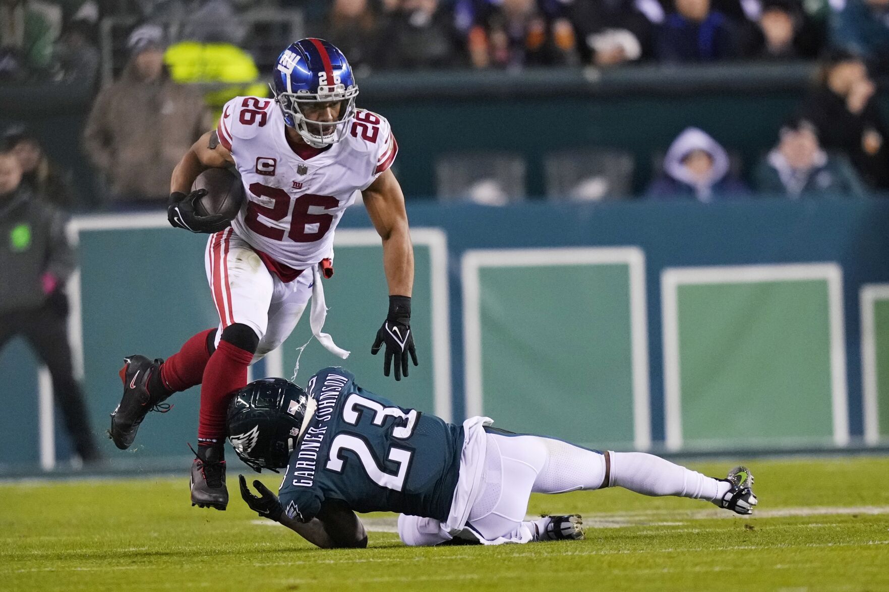 <p>New York Giants running back Saquon Barkley tries to avoid Philadelphia Eagles safety C.J. Gardner-Johnson during the second half of Sunday's NFC divisional round game in Philadelphia.</p>