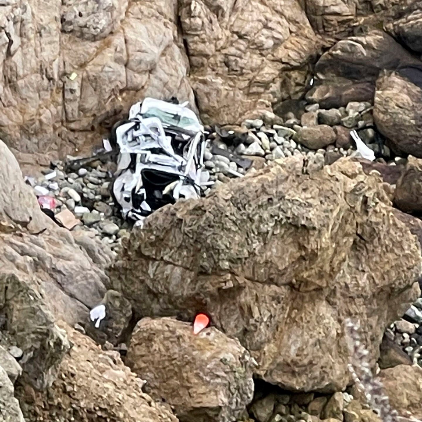 <p>This image from video provided by San Mateo County Sheriff's Office shows a Tesla vehicle that plunged off a Northern California cliff along the Pacific Coast Highway, Monday, Jan. 2, 2023, near an area known as Devil's Slide, leaving four people in critical condition, a fire official said. </p>