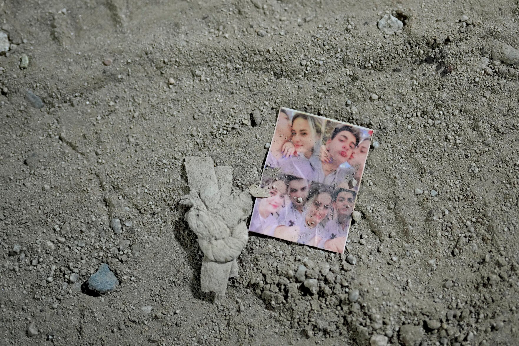 <p>A photo sits in the dirt near where migrants wait to be processed to seek asylum after crossing the border into the United States early Friday near Yuma, Ariz.</p>