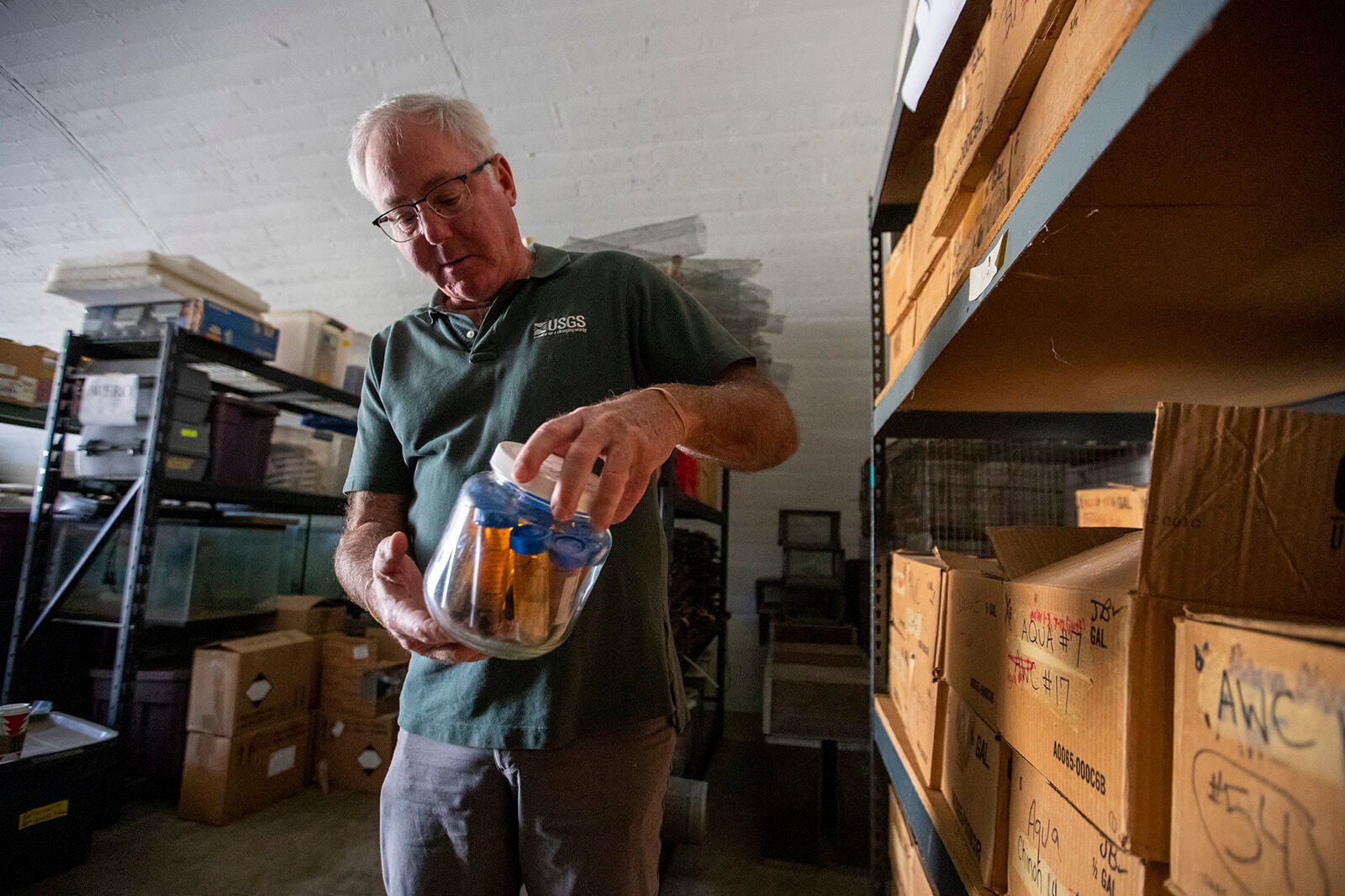 <p>U.S. Geological Survey research biologist Robert Fisher examines a jar containing vials of invertebrates collected from pitfall traps more than 20 years ago. The vials are part of his 25-year collection stored in a concrete and steel WWII munitions bunker on the former El Toro Marine Corp Air Station on Wednesday, Dec. 14, 2022, in Irvine, California. (Brian van der Brug/Los Angeles Times/TNS)</p>
