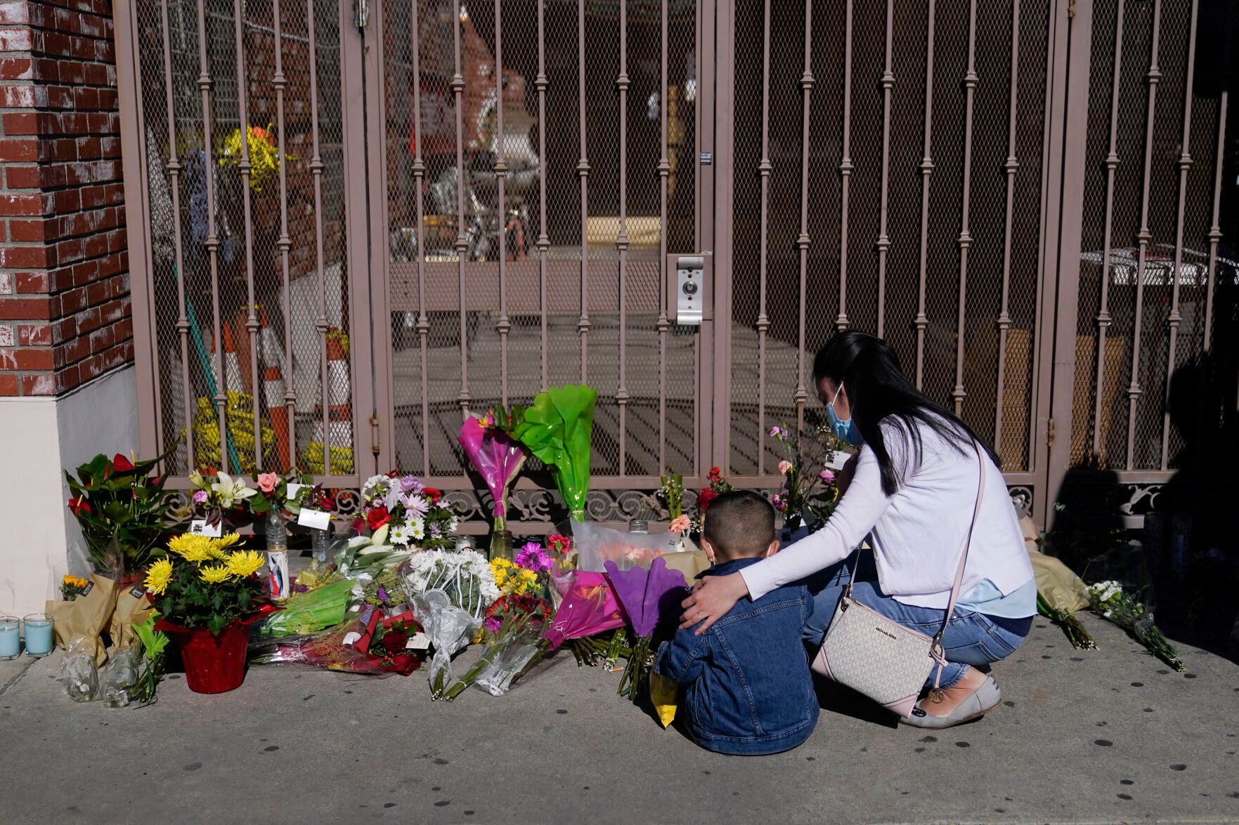 <p>A woman comforts her son while visiting a makeshift memorial outside Star Ballroom Dance Studio in Monterey Park, Calif., Monday, Jan. 23, 2023. Authorities searched for a motive for the gunman who killed multiple people at the ballroom dance studio during Lunar New Year celebrations. (AP Photo/Jae C. Hong)</p>