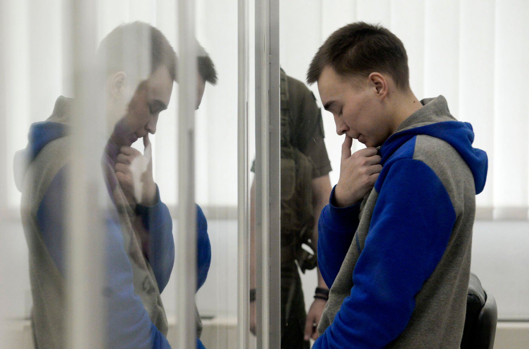 <p>Russian army Sgt. Vadim Shishimarin stands behind glass July 25 during a court hearing in Kyiv, Ukraine. The 21-year-old tank commander was the first Russian tried on war crimes charges.</p>