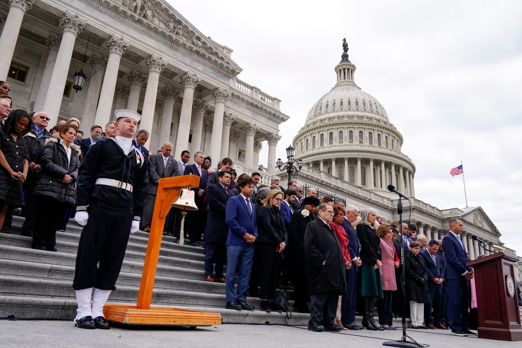 <p>House Democratic leader Hakeem Jeffries, D-N.Y., right, members of Congress and family of fallen officers pause for a moment of silence Friday in Washington on the second anniversary of the violent insurrection at the Capitol.</p>