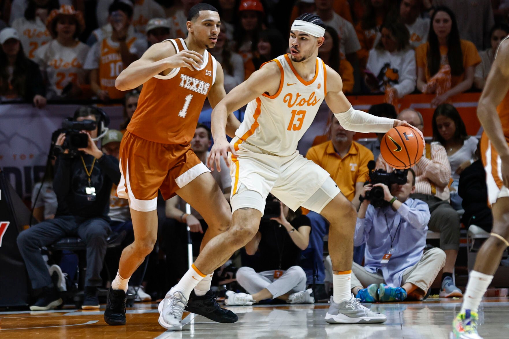 <p>Tennessee forward Olivier Nkamhoua works for a shot as he's defended by Texas forward Dylan Disu during Saturday's game in Knoxville, Tenn.</p>