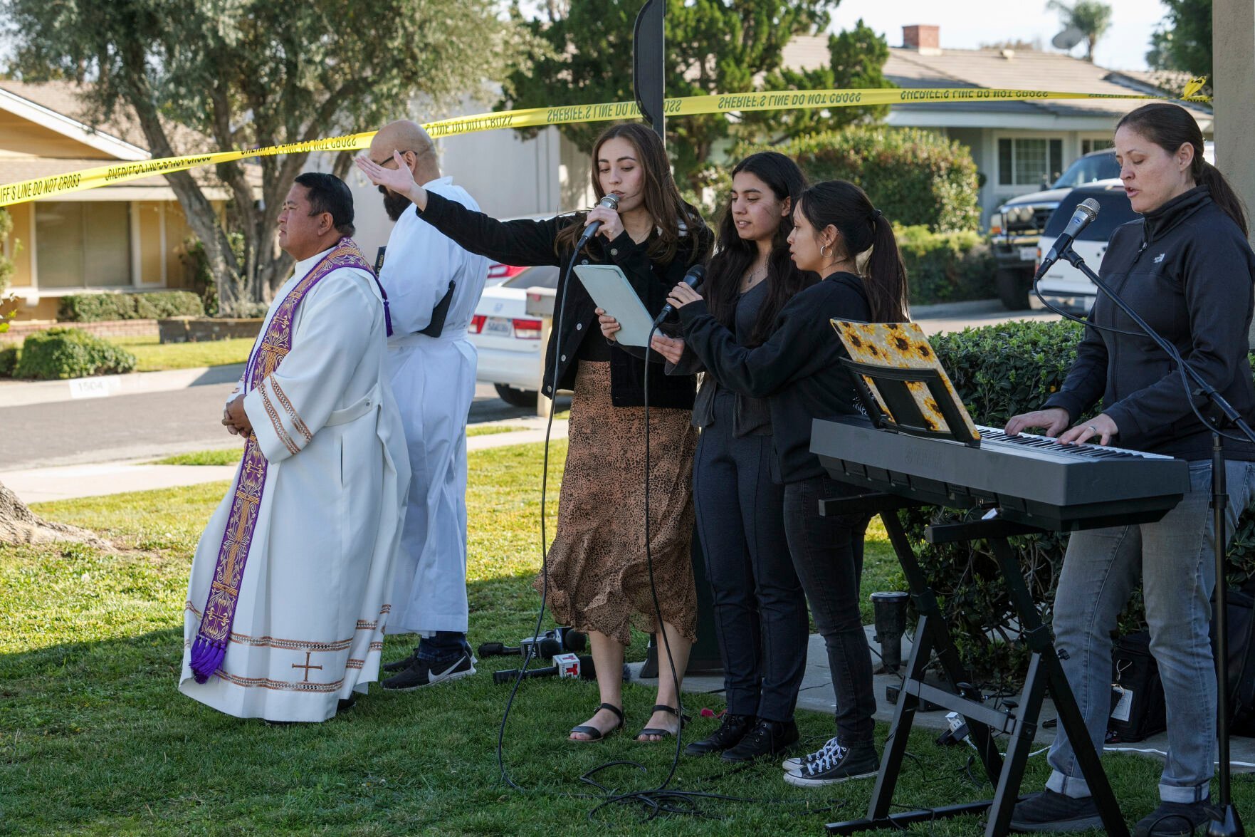 <p>Rev. Albert Avenido, far left, and Sacristan Hector Ibarra, second from left, lead members of the Sacred Heart Catholic Church in Covina, Calif., on a prayer vigil for Bishop David O'Connell at the corner of his home in Hacienda Heights, Calif., Sunday, Feb. 19, 2023. </p>