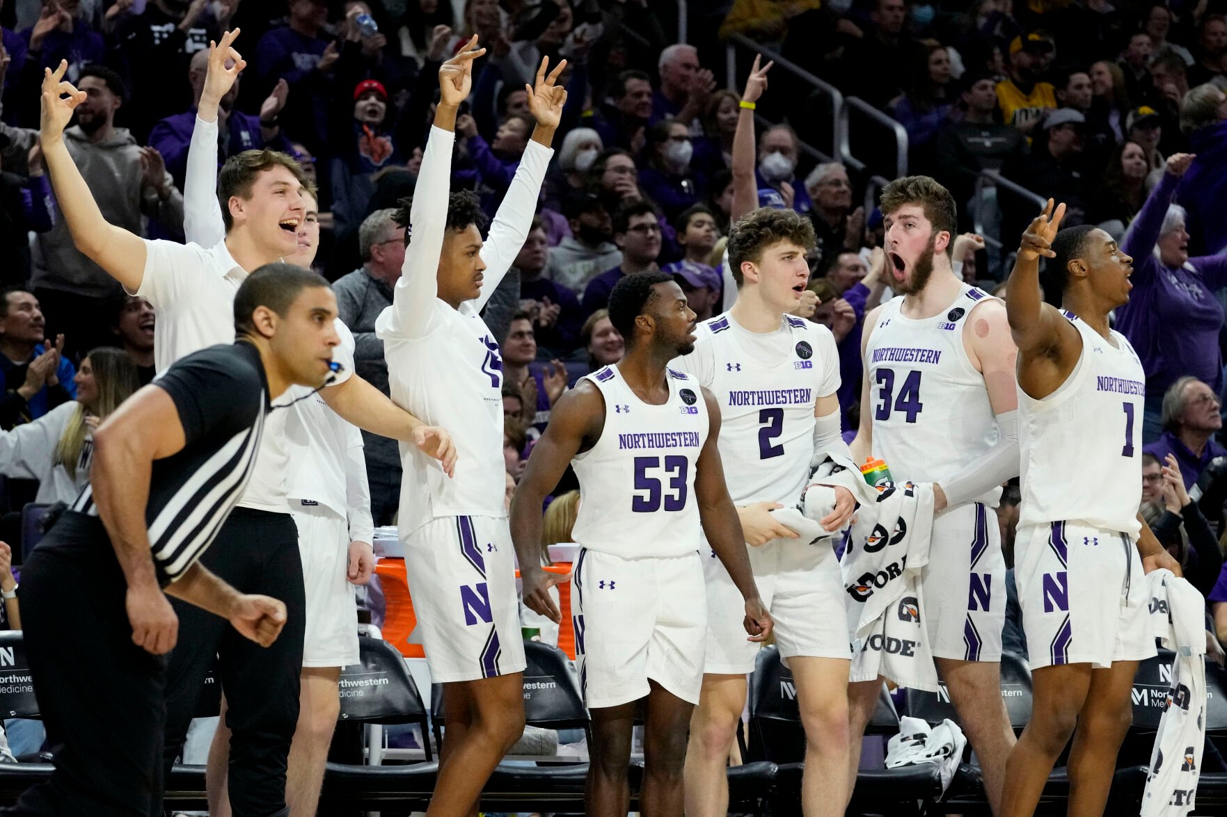 <p>Northwestern players celebrate after guard Ty Berry hit a 3-pointer during Sunday's 80-60 victory over Iowa.</p>