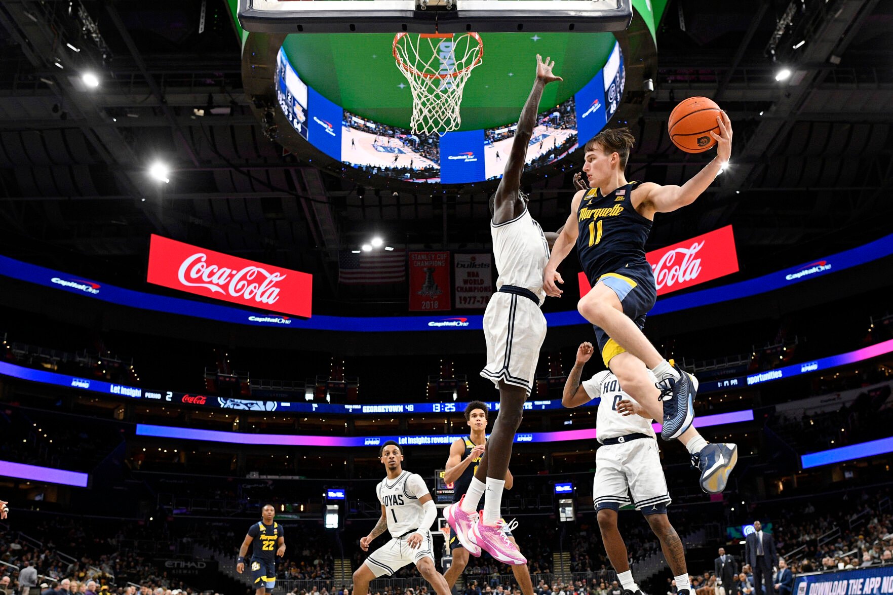 <p>Marquette guard Tyler Kolek goes to the basket against Georgetown forward Akok Akok, center, during the second half of Saturday's game in Washington.</p>
