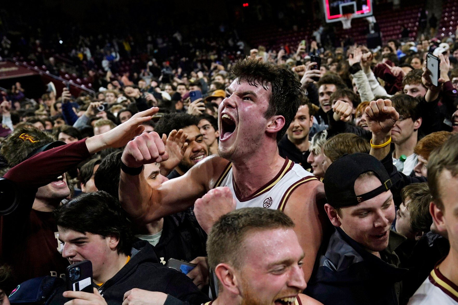 <p>Boston College forward Quinten Post celebrates with fans after Wednesday's upset victory over Virginia in Boston.</p>