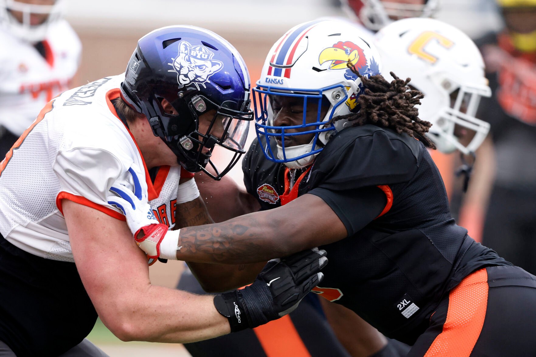 <p>National offensive lineman Blake Freeland of BYU, left, and National defensive lineman Lonnie Phelps Jr of Kansas run drills during Thursday's practice for the Senior Bowl in Mobile, Ala.</p>