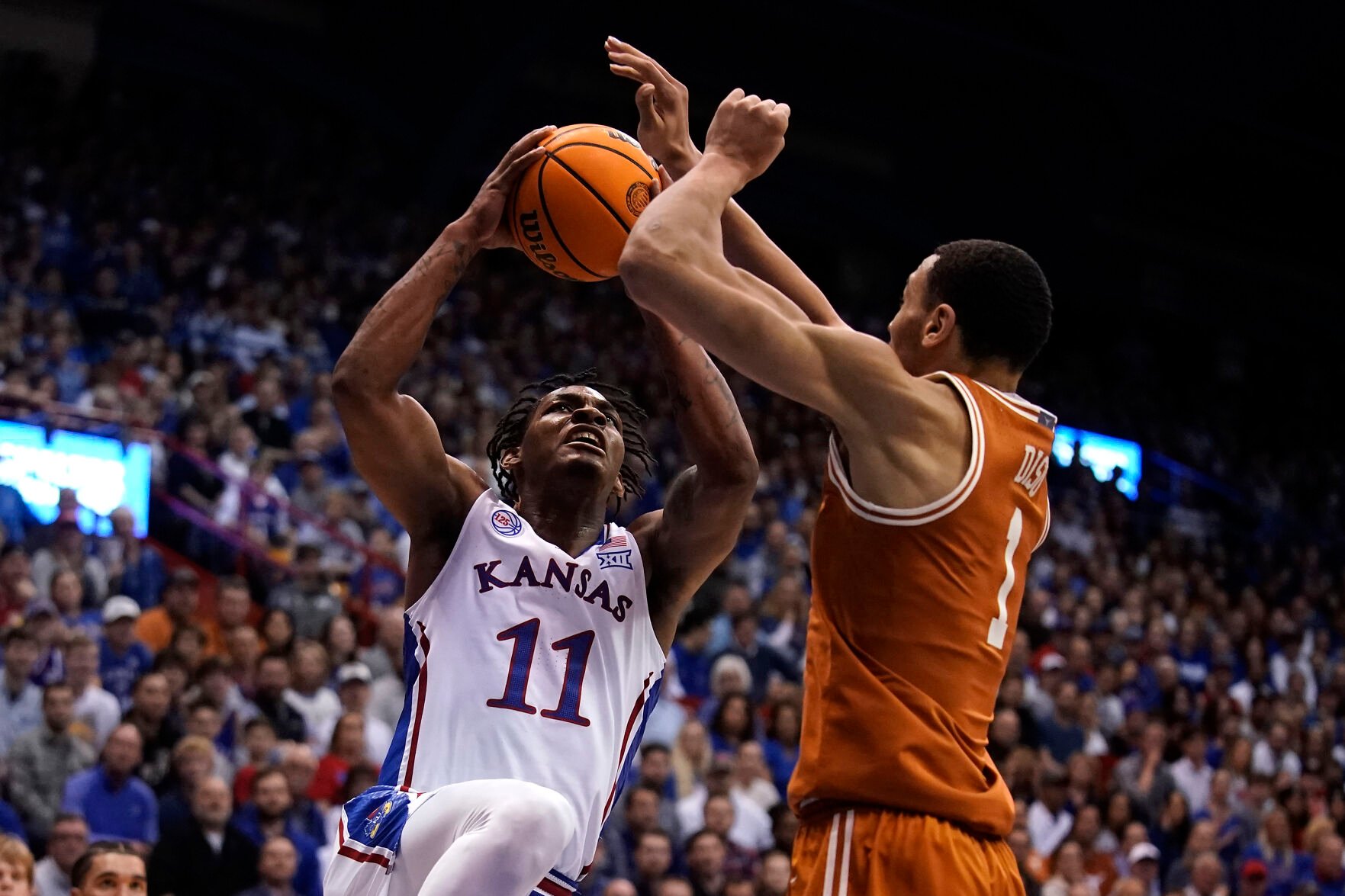 <p>Kansas guard MJ Rice, left, shoots under pressure from Texas forward Dylan Disu during the first half of Monday's game in Lawrence, Kan.</p>