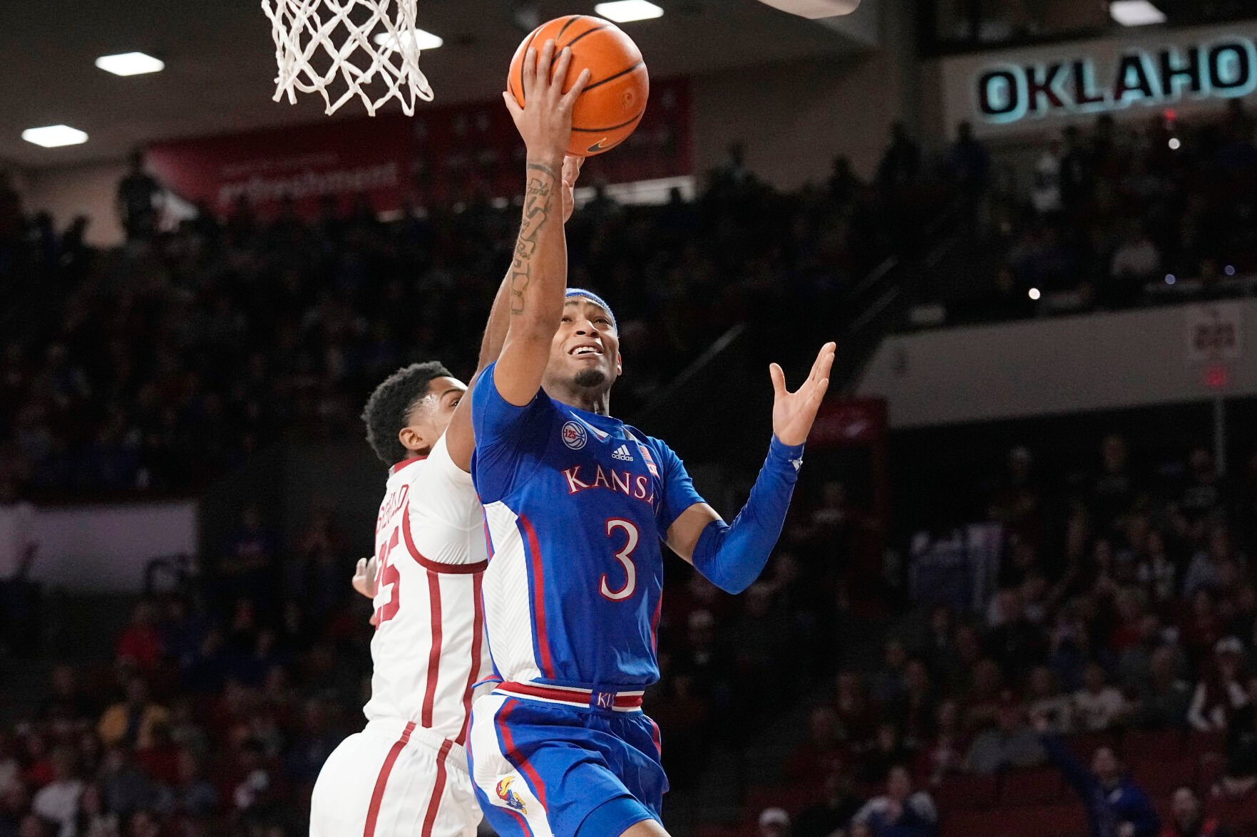<p>Kansas guard Dajuan Harris Jr. goes to the basket in front of Oklahoma guard Grant Sherfield in the first half of Saturday's game in Norman, Okla.</p>