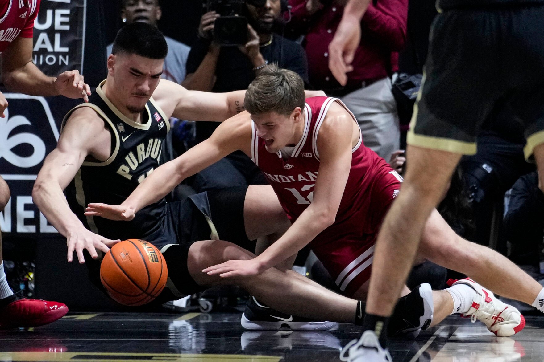 <p>Purdue center Zach Edey and Indiana forward Miller Kopp go for a loose ball during the first half of Saturday's game in West Lafayette, Ind.</p>