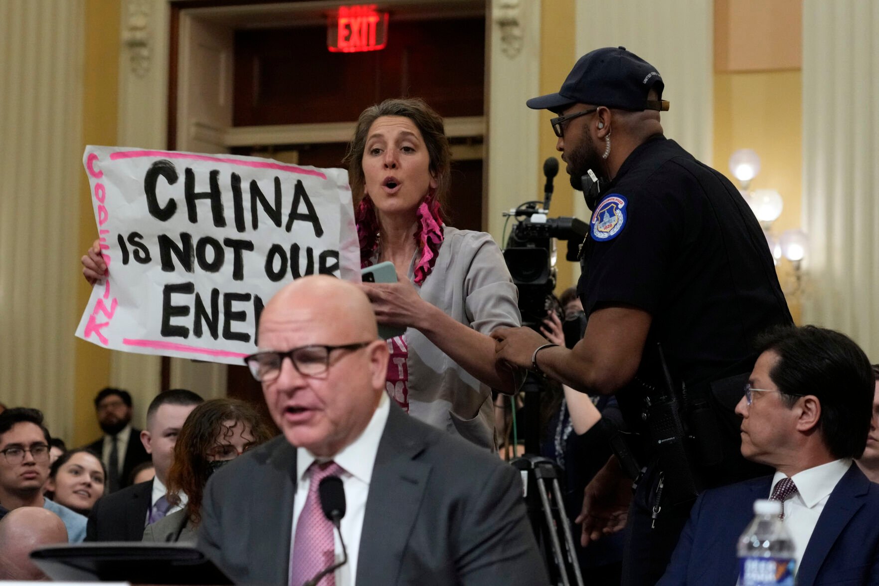 <p>U.S. Capitol Police officers remove a protester as H.R. McMaster, former national security adviser to President Donald Trump, testifies during a hearing of a special House committee dedicated to countering China, Tuesday on Capitol Hill.</p>