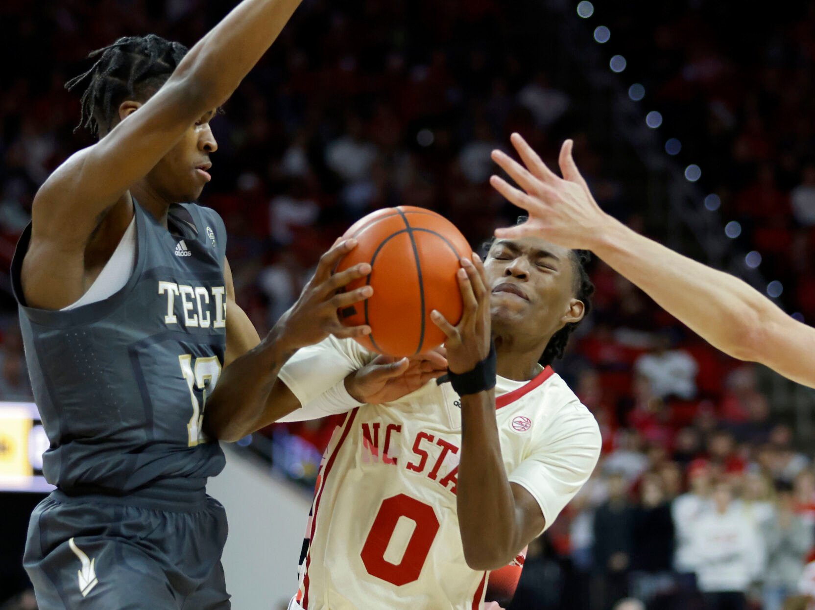 <p>North Carolina State's Terquavion Smith drives against Georgia Tech's Miles Kelly, left, and Lance Terry on Saturday.</p>