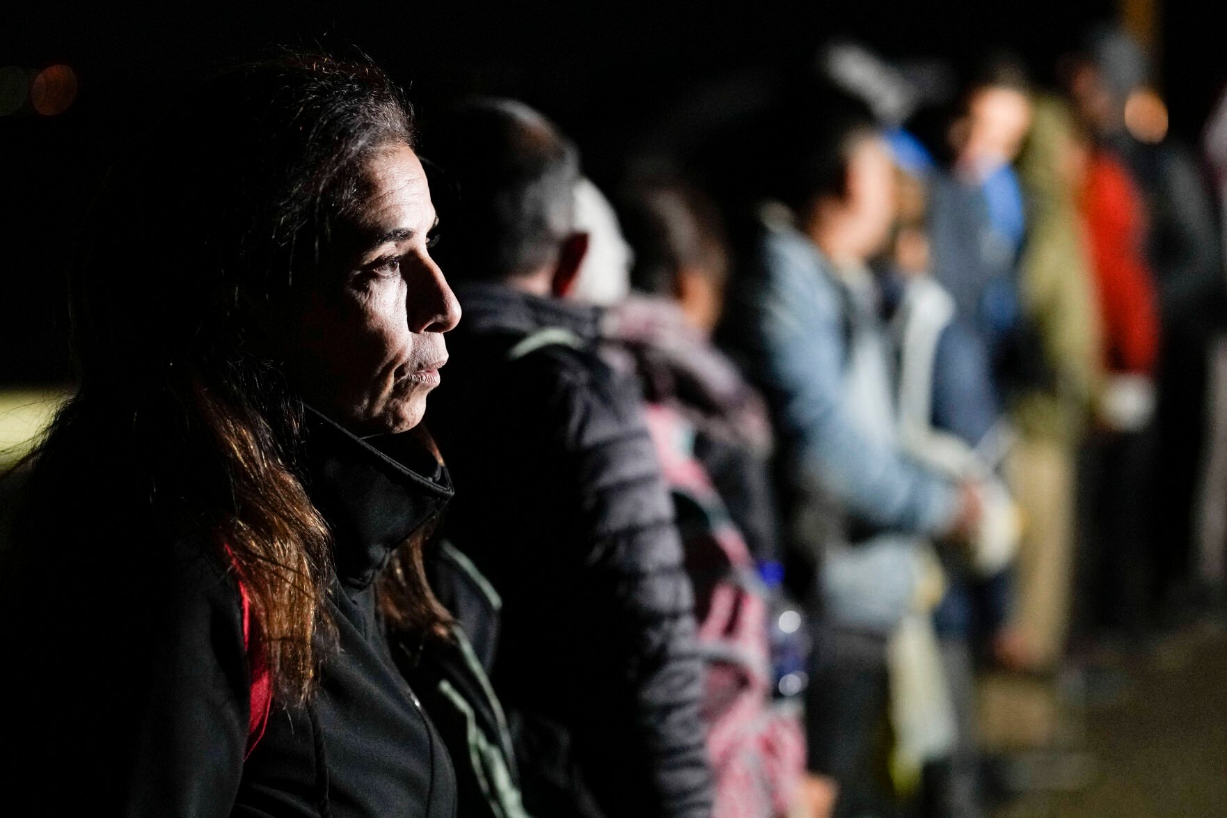 <p>A woman from Cuba waits Jan. 6 with other migrants to be processed to seek asylum after crossing the border into the United States near Yuma, Ariz.</p>