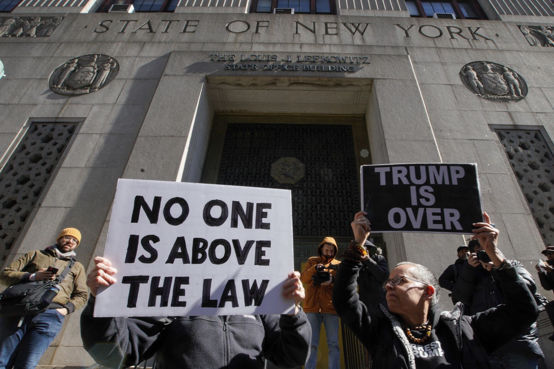 <p>People hold up posters as part of a protest in front of the courthouse ahead of former President Donald Trump's anticipated indictment on Monday, March 20, 2023, in New York. (AP Photo/Eduardo Munoz Alvarez)</p>