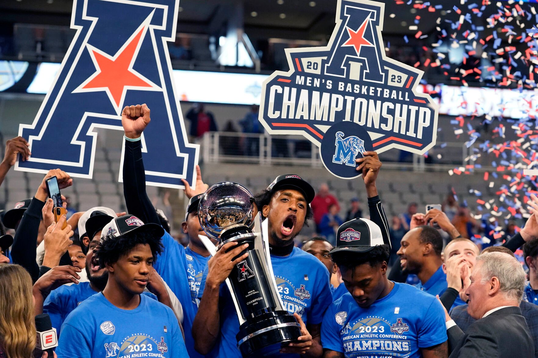 <p>Memphis forward DeAndre Williams, center, holds the winner's trophy with Kendric Davis, left, Alex Lomax, right, and other teammates after winning Sunday's American Athletic Conference final against Houston in Fort Worth, Texas.</p>