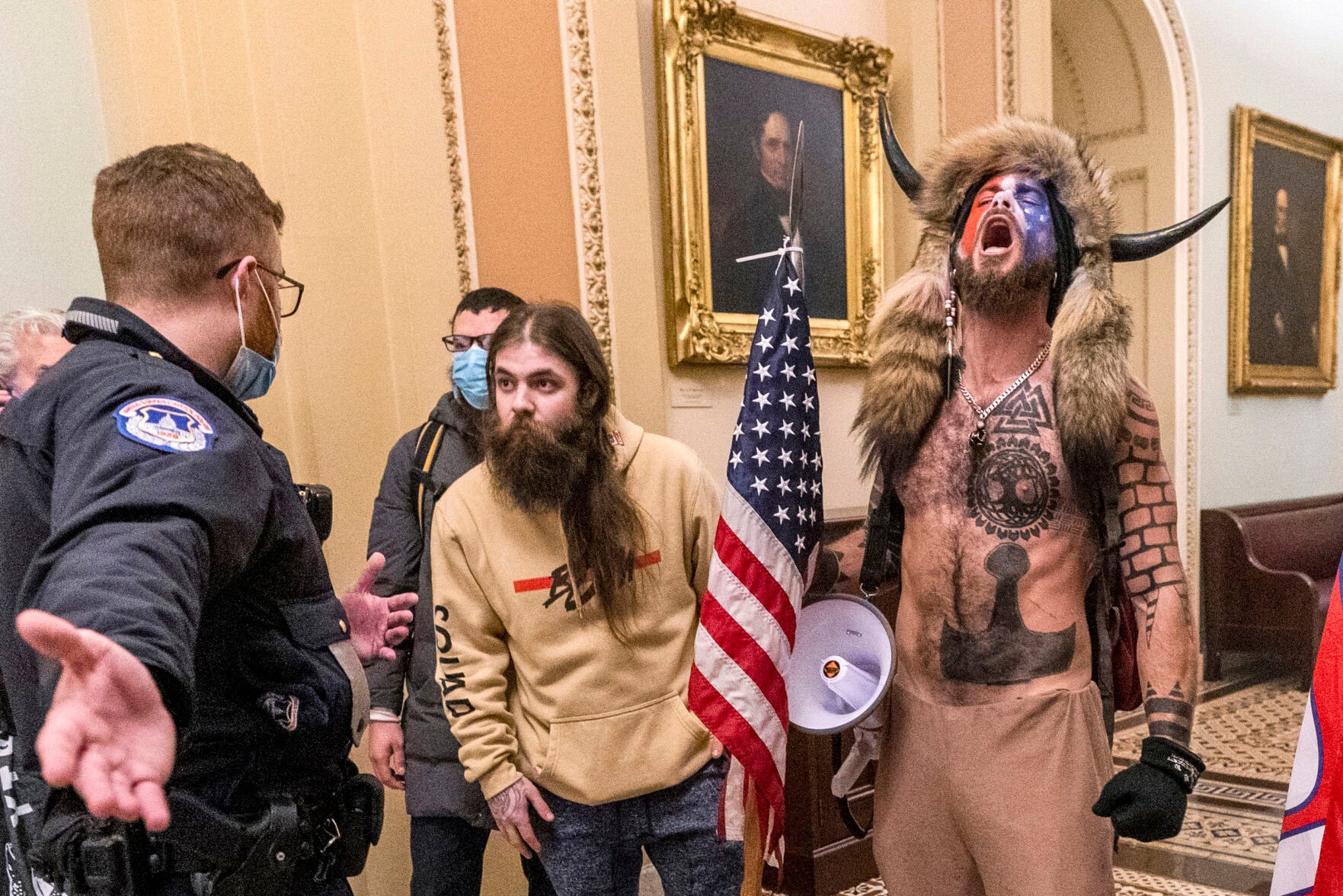 <p>FILE - FILE - In this Jan. 6, 2021 file photo, supporters of President Donald Trump, including Jacob Chansley, right with fur hat, are confronted by U.S. Capitol Police officers outside the Senate Chamber inside the Capitol in Washington. On Friday, March 10, 2023, The Associated Press reported on stories circulating online incorrectly claiming footage from the Jan. 6, 2021, attack on the U.S. Capitol shows that Chansley was “led through the Capitol by police the entire time he was in the building.” (AP Photo/Manuel Balce Ceneta, File)</p>