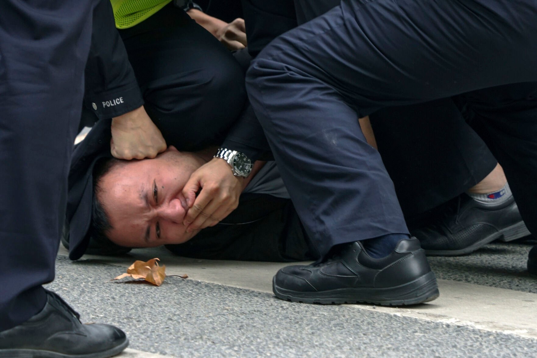 <p>Chinese policemen pin down a protester during a protest against anti-virus measures Nov. 27, 2022, on a street in Shanghai.</p>