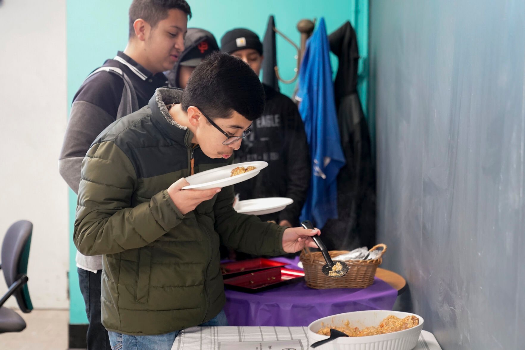 <p>Jefferson Martinez smells the chipotle arroz con pollo before trying the dish as Mount Diablo High School students participated in a taste test on Jan. 13 in Concord, Calif.</p>