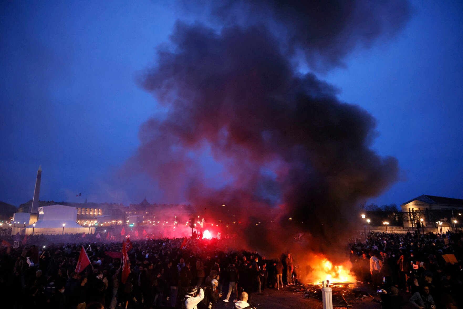 <p>Pallets burn as protesters demonstrate at Concorde square near the National Assembly in Paris, Thursday, March 16, 2023. French President Emmanuel Macron has shunned parliament and opted to push through a highly unpopular bill that would raise the retirement age from 62 to 64 by triggering a special constitutional power. (AP Photo/Thomas Padilla)</p>