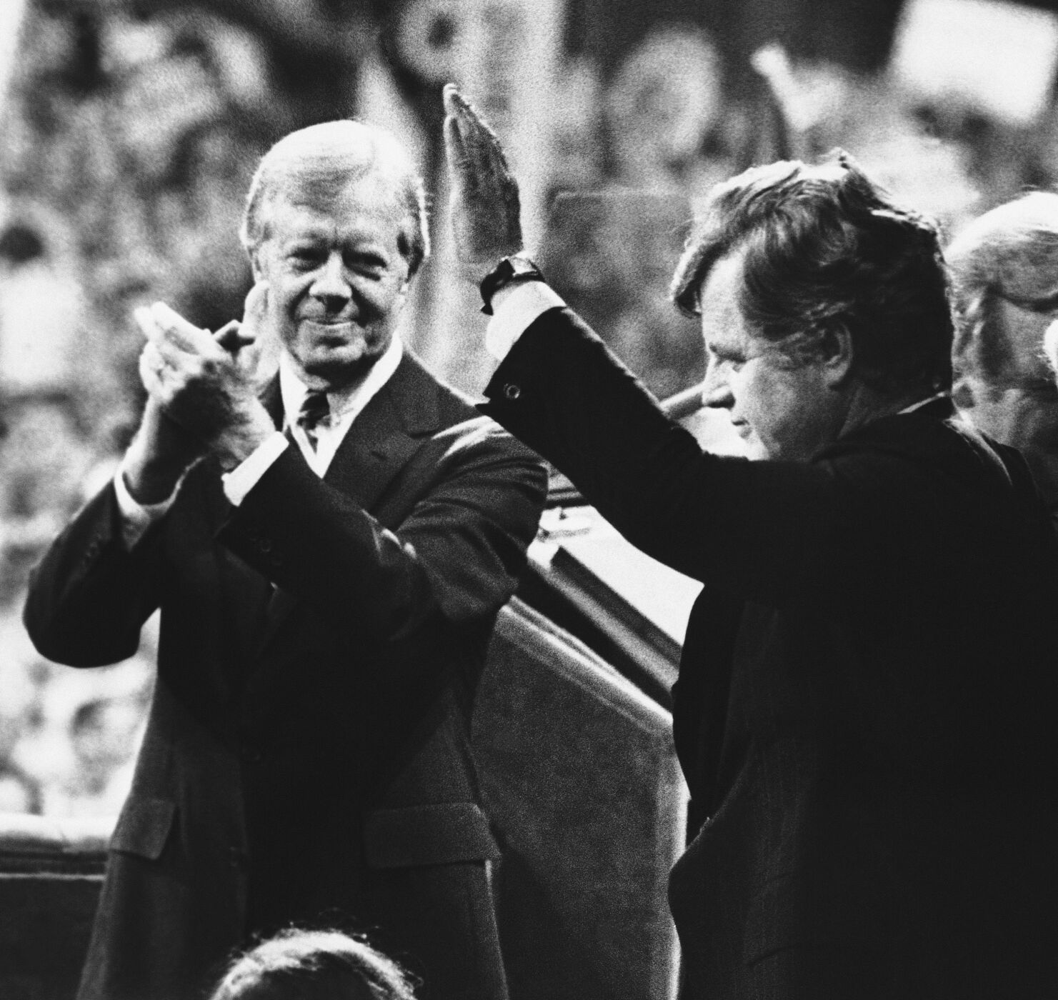 <p>FILE - U.S. President Jimmy Carter, left, applauds as Sen. Edward Kennedy waves to cheering delegates at the Democratic National Convention in New York's Madison Square Garden, Aug. 14, 1980.</p>